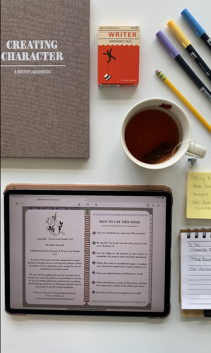 Product flat lay showing the digital character workbook writing tool on an ipad amidst a physical workbook, cup of tea, pens, and writing tools.