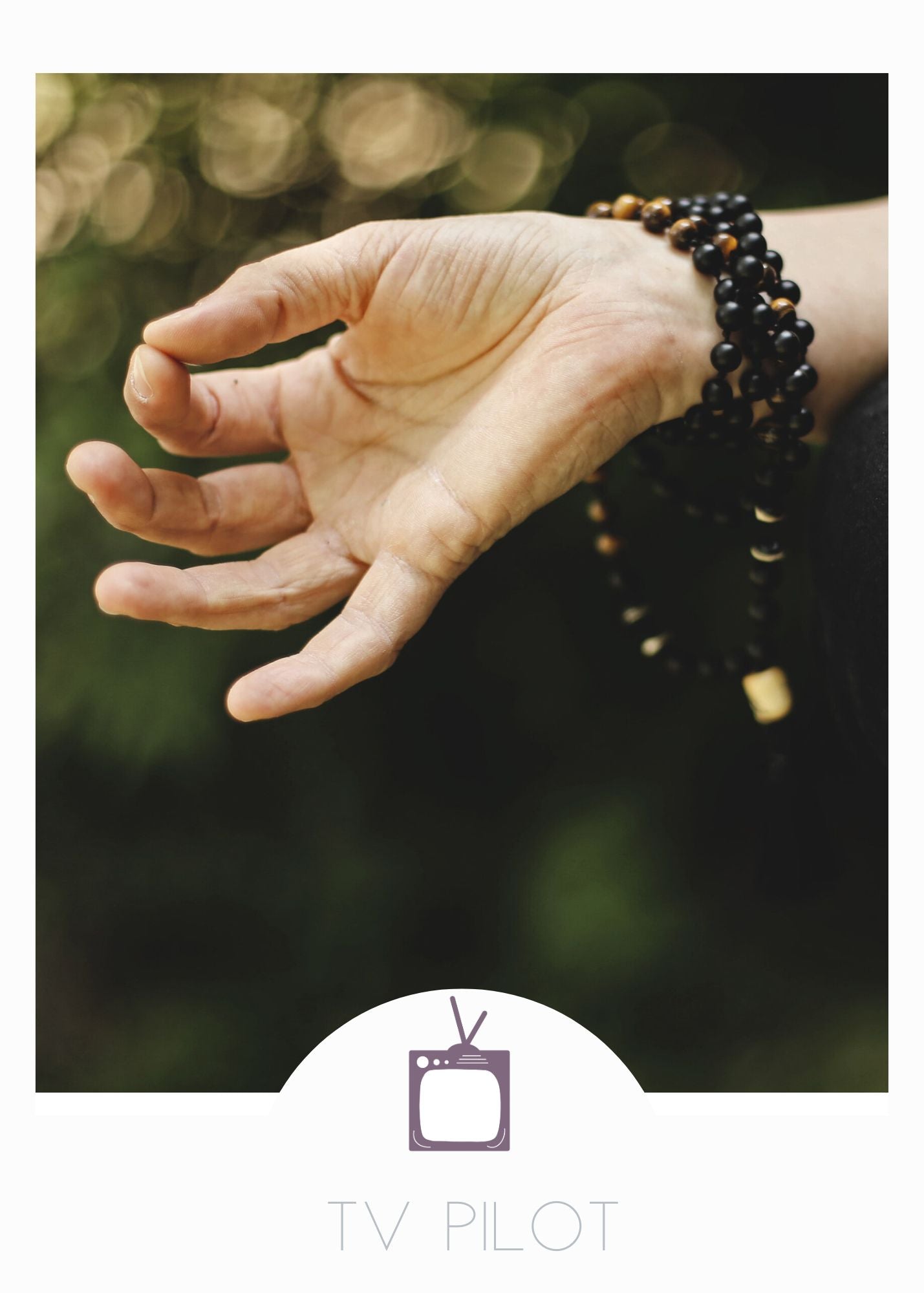 A hand in guyan mudra with a bracelet of mala beads. A reference photo for the TV Pilot screenplay Retreat written by Emily Prescott